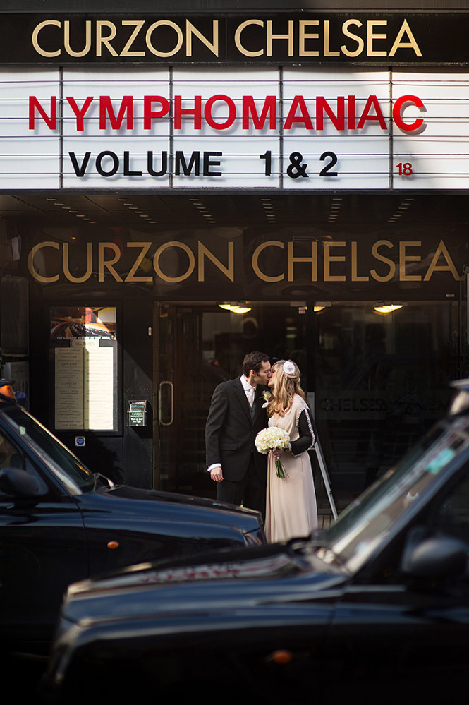 Newly weds kissing outside the old Curson cinema on the Kings Road, Chelsea. Sign reads: 'Nymphomaniac Volume 1 and 2'