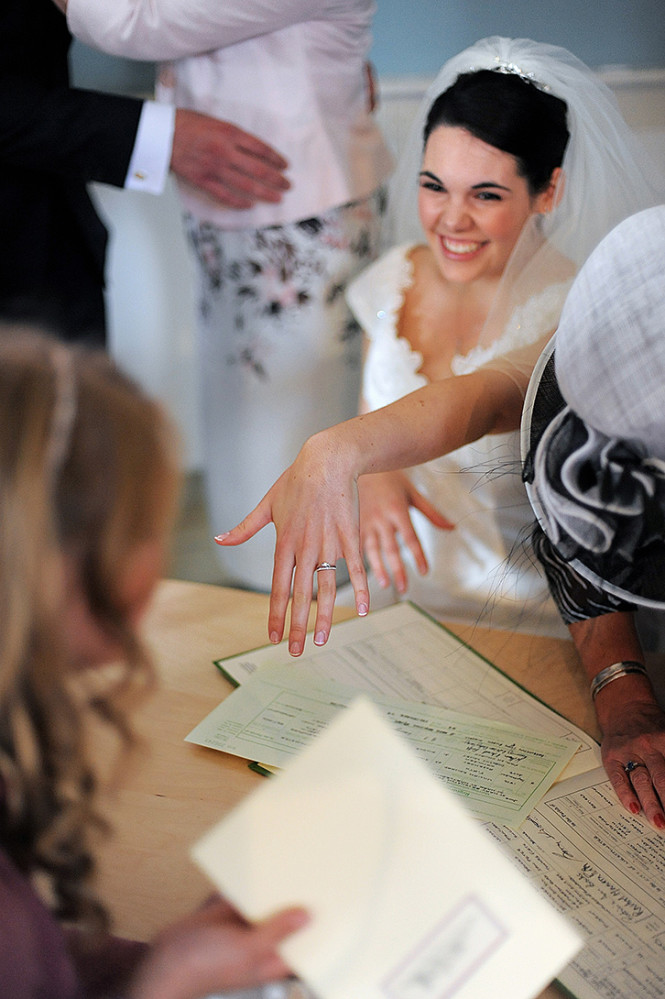 Bride shows her wedding ring during the register signing in a church in London.