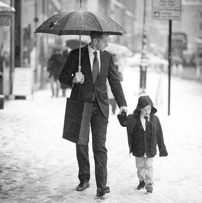 Groom and his young son walk through Knightsbridge in the snow.