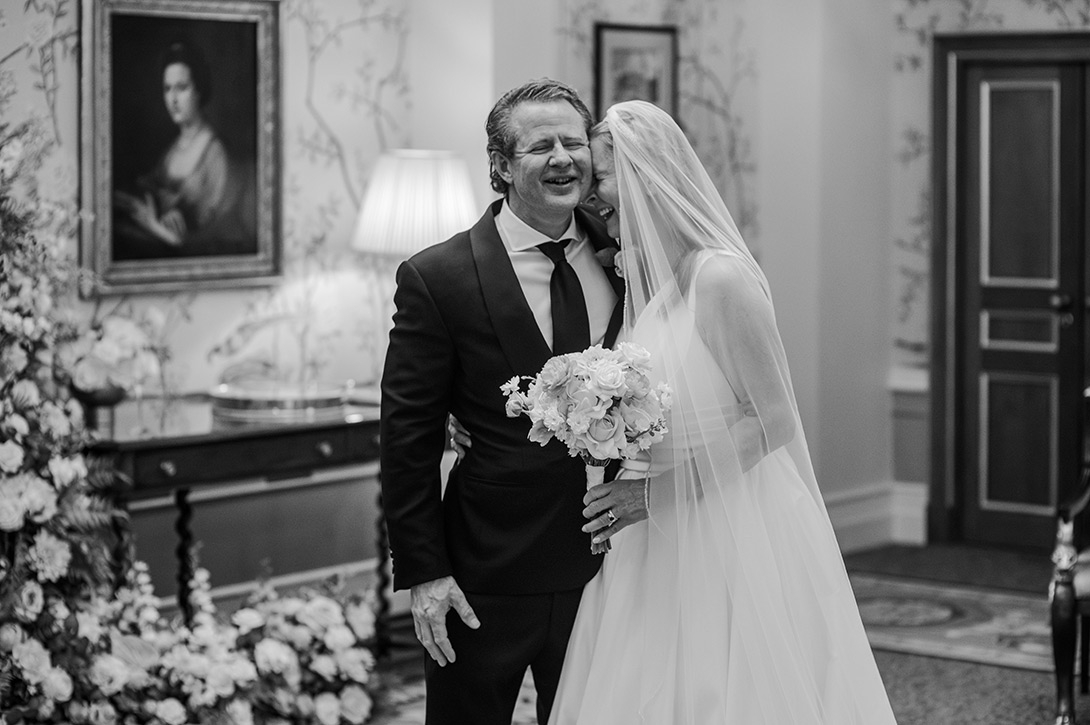 lanesbourough-hotel-wedding - Wedding photographer London Bride in a wedding dress and veil shares a kiss with a smiling man in a dark suit, at the Lanesborough
