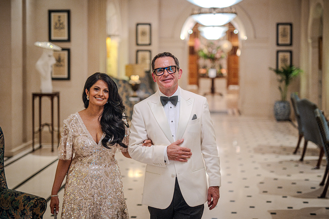 wedding-couple-reportage-lanesbourough - Wedding photographer London Smiling couple in formal attire walking arm-in-arm through a marble hotel lobby.